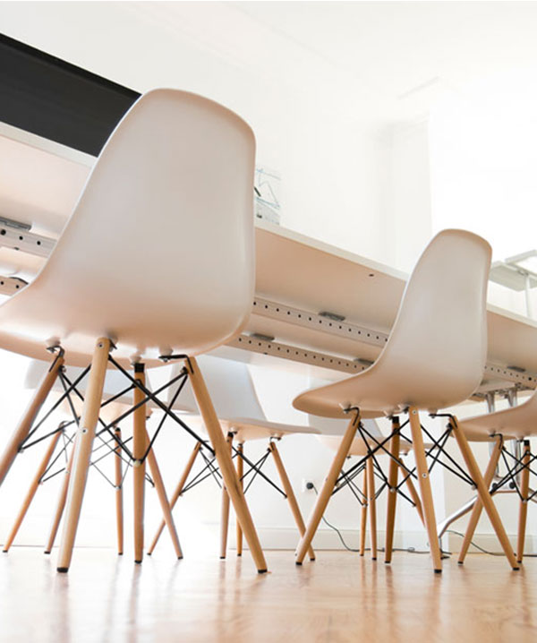 Untersicht auf mehrere Stühle, die an einem Tisch stehen. Du suchst einen Job in der Aksis Werbeagentur Ulm?